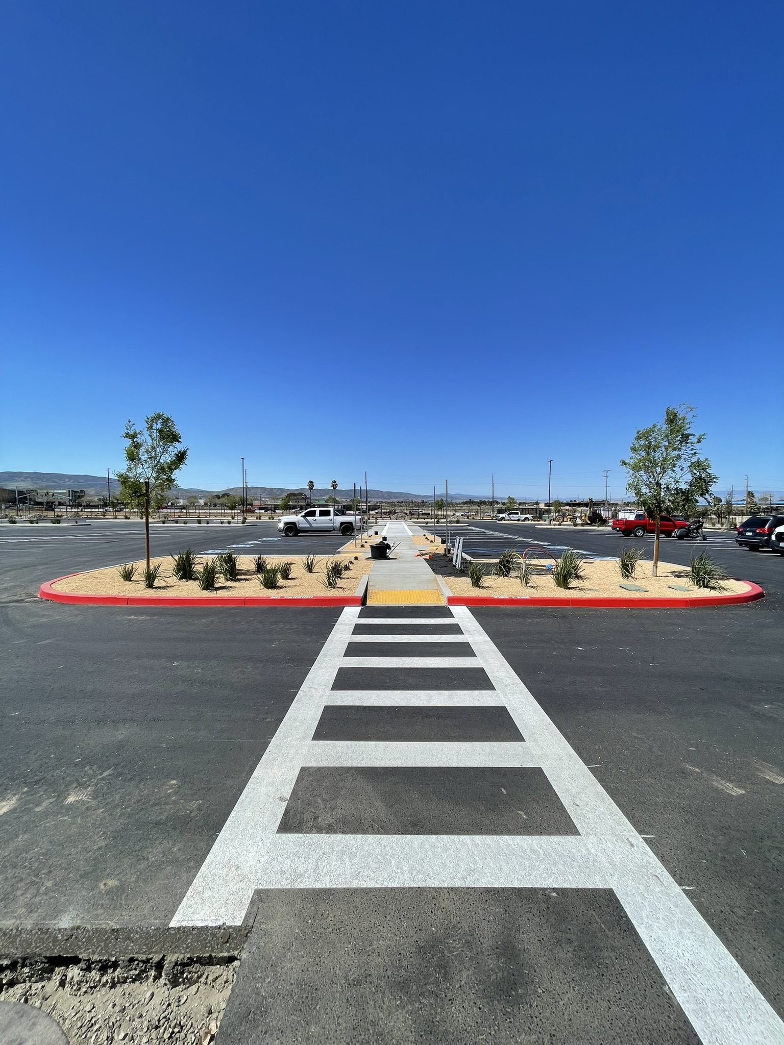 A street with a crosswalk and parking lot.