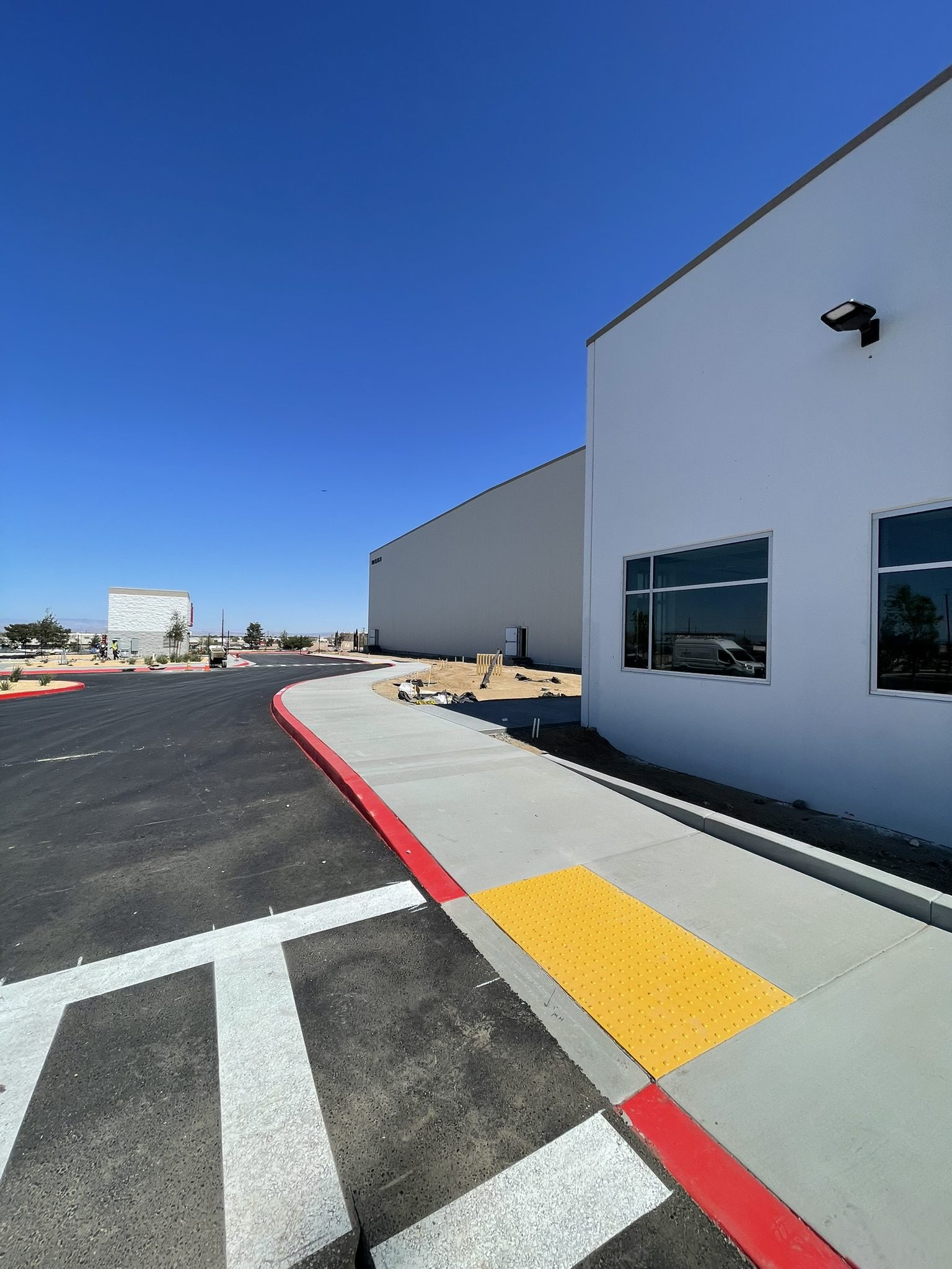 A parking lot with a building and street markings.