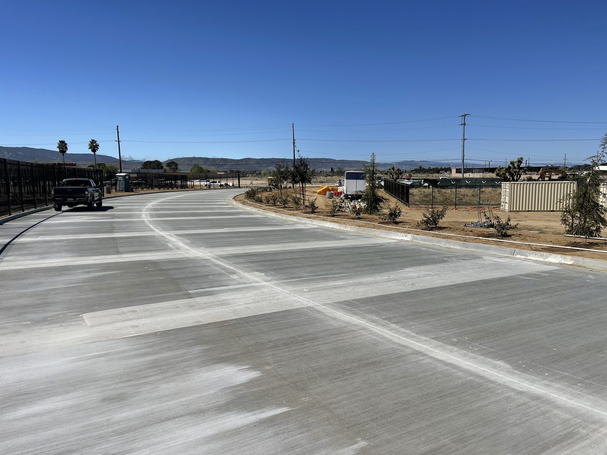 A road with no traffic on it and a truck driving down the street.
