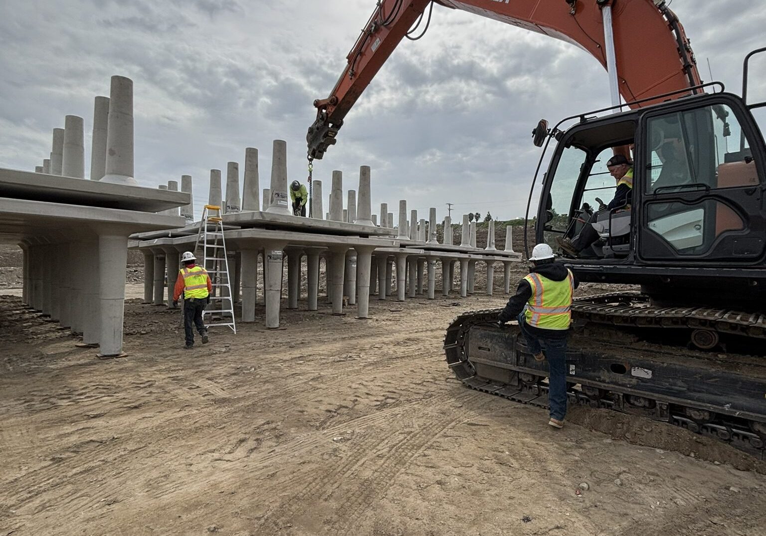 A construction worker standing next to a large machine.